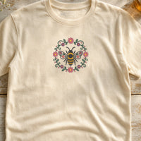 Bee Circle Flowers embroidery design stitched on a natural cream relaxed cotton t-shirt
