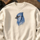 BlueJay Bird Head Threads embroidery design stitched on a natural cream heavyweight fleece crewneck sweatshirt
