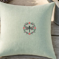Dragonfly Circle Flowers embroidery design stitched on a 16-inch linen-blend throw pillow cover in pale mint