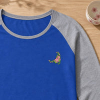 Flower Corner Cherry Blossom embroidery design stitched on a royal blue women's long-sleeve baseball raglan