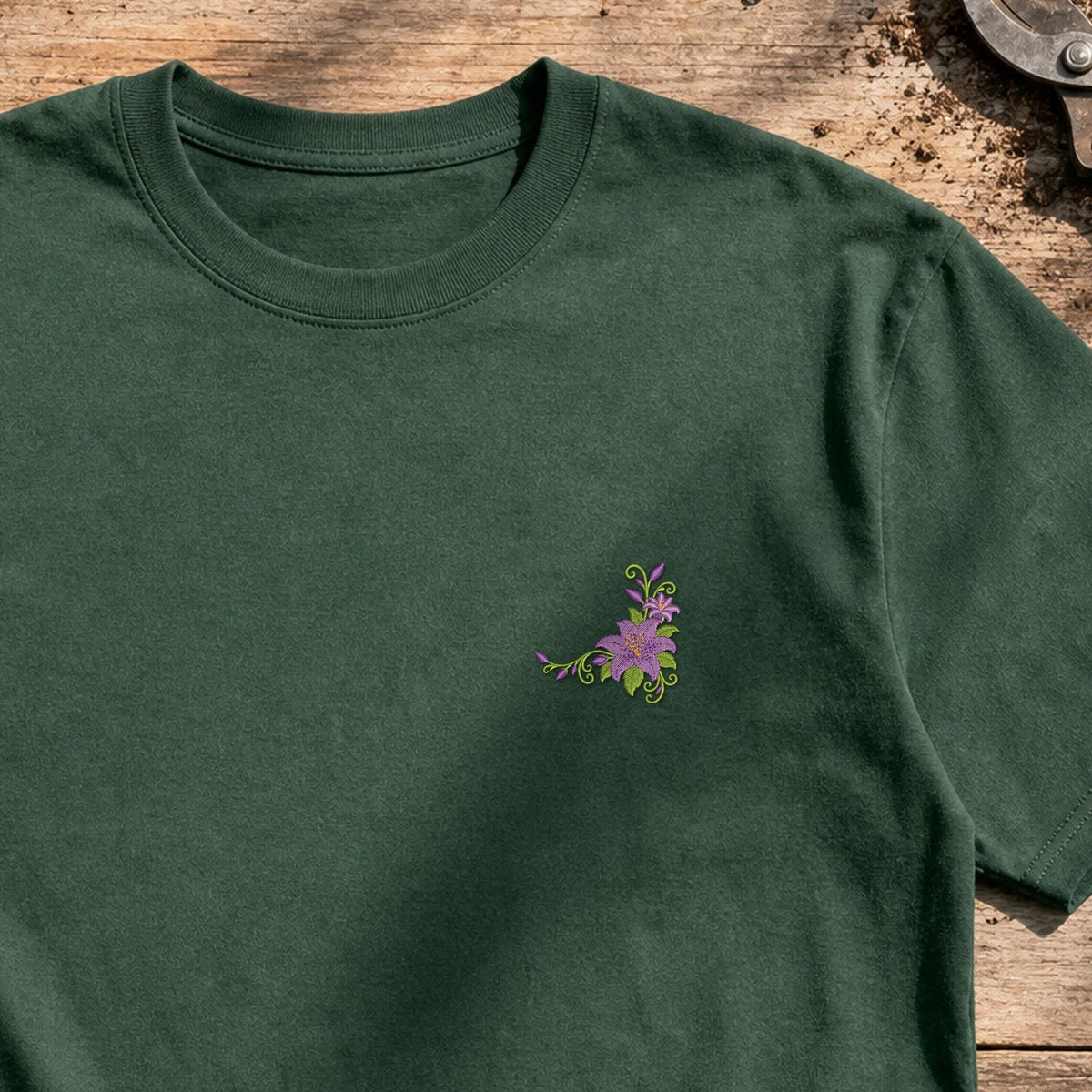 Flower Corner Lily embroidery design stitched on a forest green relaxed-fit short-sleeve cotton crewneck tee