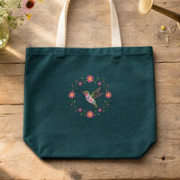 Hummingbird Circle Flowers embroidery design stitched on a deep teal heavy canvas tote bag