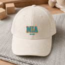 MIA Puff Cap embroidery design stitched on a soft ivory structured six-panel baseball cap