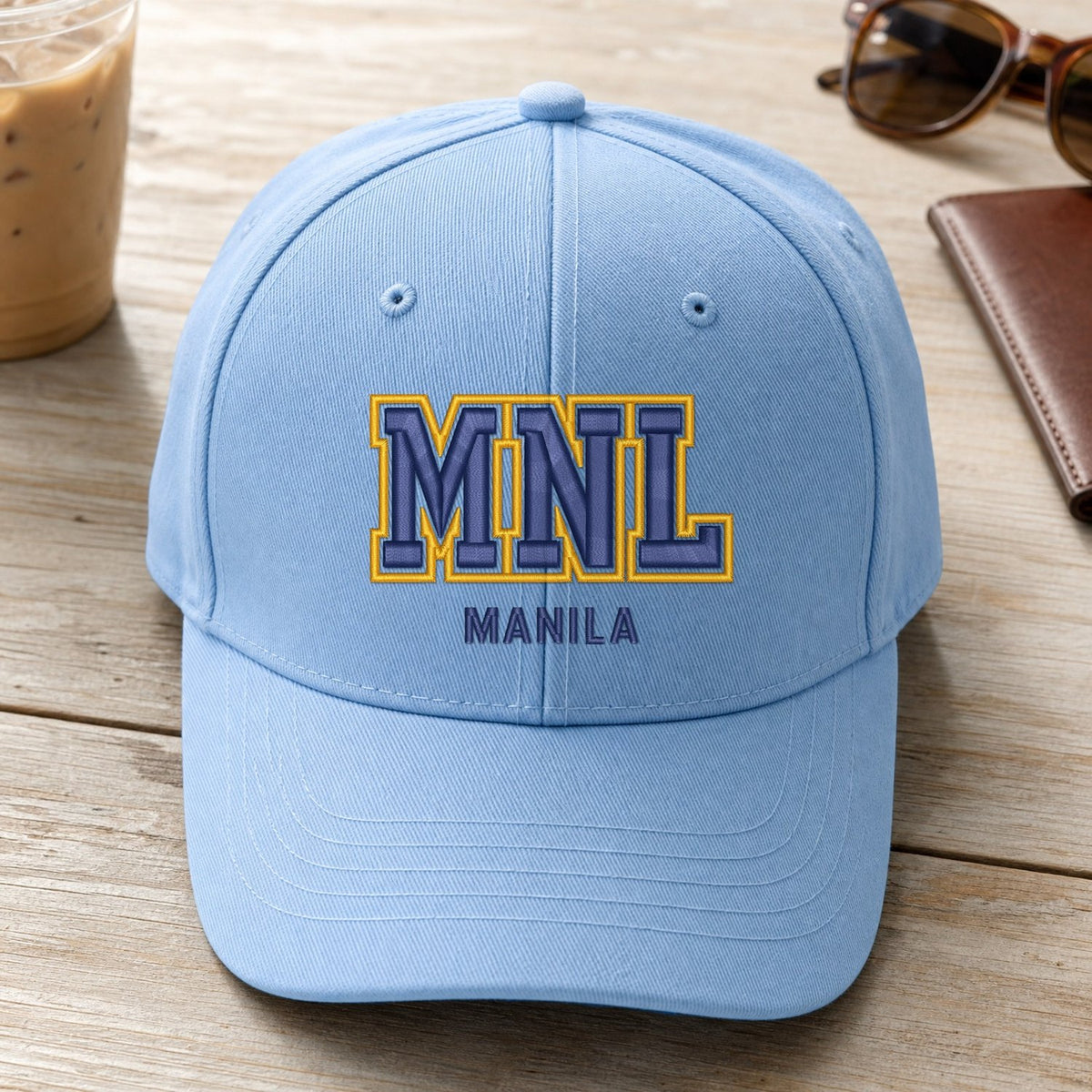 MNL Puff Cap embroidery design stitched on a light sky blue structured six-panel baseball cap