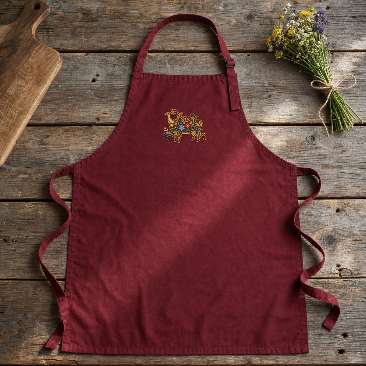 Sheep Filled Flowers embroidery design stitched on a maroon cotton kitchen bib apron