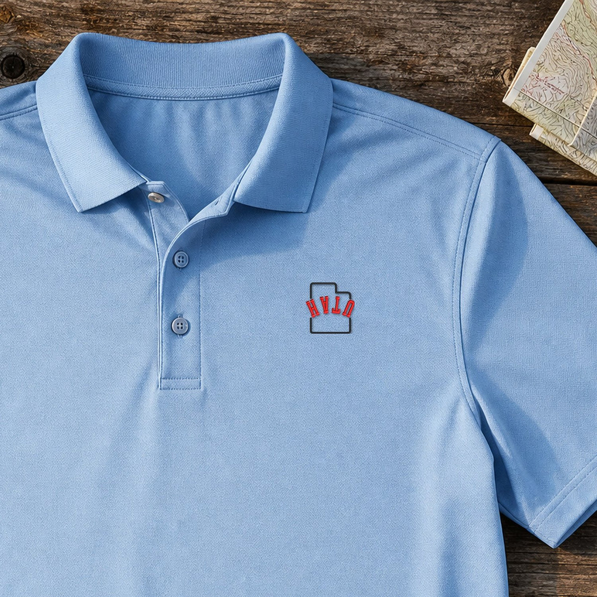 Utah State Upside Down embroidery design stitched on a sky blue lightweight performance polo